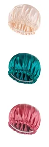 Detail of satin hair bonnets in pink, green, and red with elastic ruffled edges