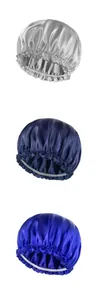 Close-up of satin hair bonnets in silver, dark blue, and bright blue with elastic bands