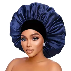 Detail view of a large satin sleep bonnet with a wide black elastic band and blue fabric
