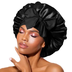 Detail of pure black satin hair bonnet with a large decorative bow and shiny texture
