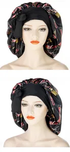 Detailaufnahme der schwarzen Satin-Schlafmütze mit Vintage-Druck und breitem Stirnband
