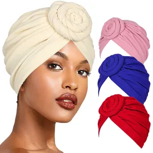 Detail of bohemian turban hats featuring 3D floral rosettes and soft pleated fabric textures