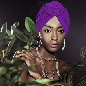 Elegant purple turban hat with rose knot detail for women in a tropical outdoor setting