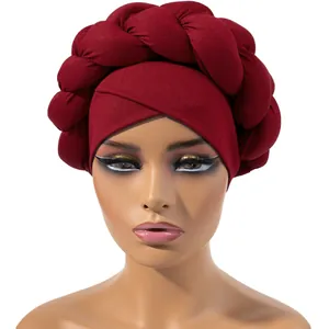 Dettaglio del turbante rosso vino in seta di latte con design a treccia spessa