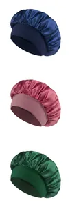 Detailed view of elastic satin sleep bonnets in navy, burgundy, and dark green colors