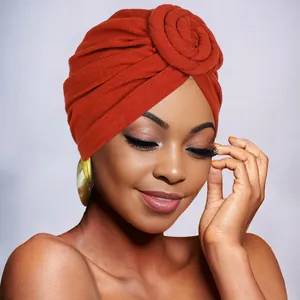Close-up of burnt orange bohemian turban hat with stylish top twist knot detail