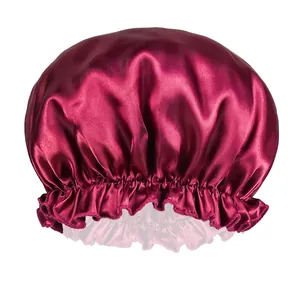 Detailed view of smooth wine red satin fabric and elastic pleated edge of the sleep cap