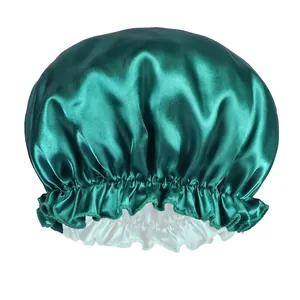Close-up of dark green satin hair bonnet with elastic lace edge and grey lining