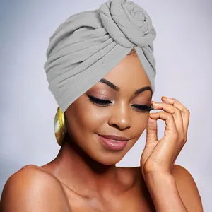 Detail of grey knit turban hat featuring a decorative layered floral knot design