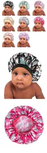 Close-up of baby satin bonnets with colorful unicorn prints and wide elastic bands