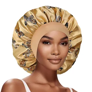 Détail du bonnet en satin doré avec imprimé papillon et bandeau élastique large