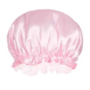 Close-up of pink satin hair bonnet with elastic band and decorative ruffle details