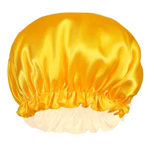 Detailed close-up of yellow satin hair bonnet with ruffled edges and elastic band texture