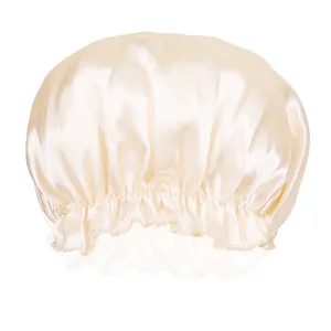 Detail of champagne satin hair bonnet showing the elastic lace edge and silky texture