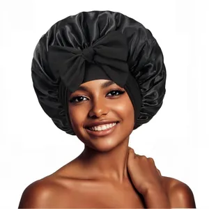 Détail du bonnet de nuit en satin noir avec un grand nœud décoratif sur un modèle