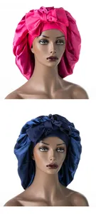 Dettaglio di cuffie da notte in raso di seta magenta e blu navy con grandi fiocchi decorativi