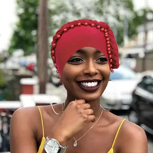 Turbante rosso da donna con bordo intrecciato e decorazioni di perline coordinate