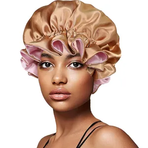 Detail of champagne gold satin sleep cap with pink lining and ruffled edges for hair care
