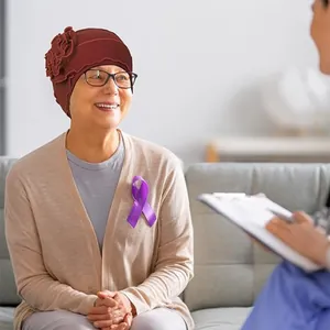 Detail of burgundy turban cap with pleated flower worn by smiling patient in care center