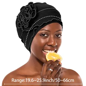Detail showing the elastic black turban fabric and a large 3D layered side flower detail