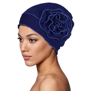 Detail of navy blue turban hat featuring a large 3D layered fabric flower and soft knit texture