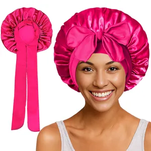 Détail du bonnet de nuit en satin rose avec grand nœud et longs rubans ajustables