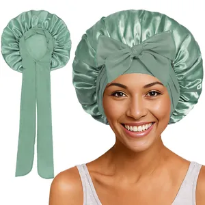 Détail du bonnet de nuit en satin vert sauge avec ruban ajustable et grand nœud