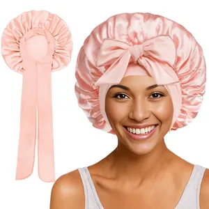 Vue détaillée d'un bonnet de nuit en satin rose clair avec bande élastique et grand nœud