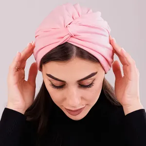 Close-up of a light pink knotted turban hat for women in soft stretch jersey fabric