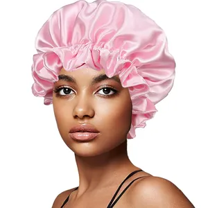 Close-up of pink satin sleep bonnet with elastic ruffled edge on female model