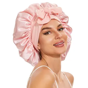 Détail d'un bonnet de nuit en satin rose avec un grand nœud et une bande élastique