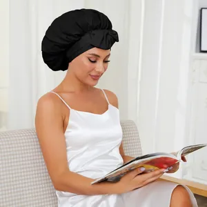 Détail d'un bonnet de nuit en satin noir avec nœud décoratif pour protéger les cheveux