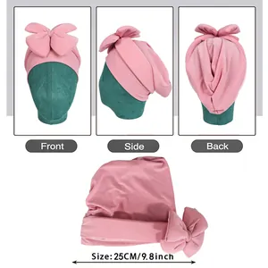 Pink bow baby turban hat made of soft stretch fabric shown in front and side views