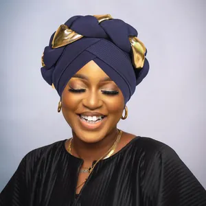 Close-up of twist turban hat featuring navy blue knit and metallic gold braid detail