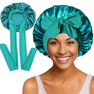 Gros plan détaillé du bonnet en satin bleu sarcelle avec texture soyeuse et nœud