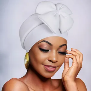 Close-up of white stretch turban hat with oversized bow decoration for women