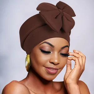 Close-up of brown bow turban hat showing ribbed fabric texture and large bow detail