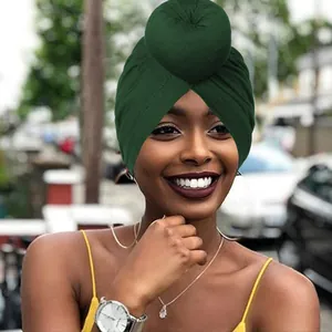 Turbante verde scuro con nodo a sfera su modella per uno stile di moda quotidiana
