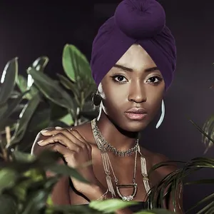 Turbante viola scuro elasticizzato con nodo a sfera indossato da una modella in stile esotico