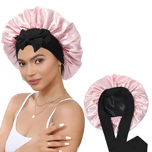Détail du bonnet de nuit en satin rose avec large ruban élastique noir noué sur le front