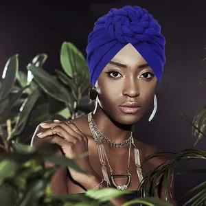 Royal blue knit turban hat with elegant twisted flower design on a female model