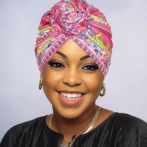 Close-up of vibrant floral print turban with decorative 3D rose knot detail