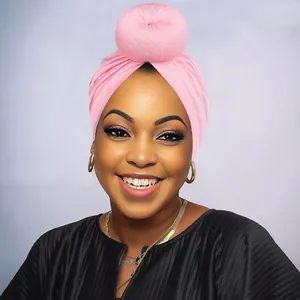 Dettaglio del turbante rosa con nodo a ciambella e trama morbida in maglia elastica