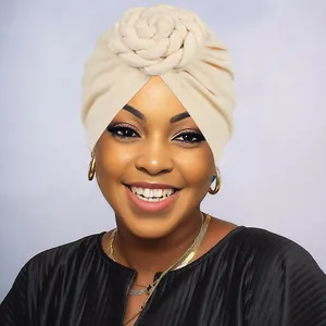Close-up of beige knit turban with intricate handmade 3D floral weave decoration