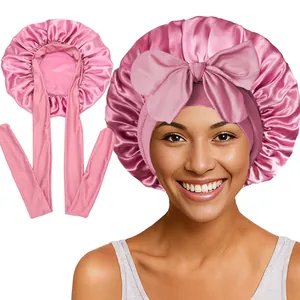 Détail du bonnet de nuit en satin rose avec long ruban et grand nœud décoratif
