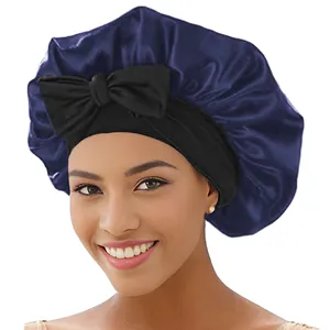 Detailansicht einer blauen Satin-Schlafmütze mit schwarzem Gummiband und Schleife