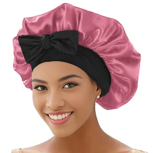 Detail der rosa Satin-Schlafhaube mit breitem schwarzem Gummiband und Zierschleife
