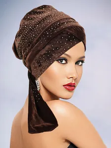 Detailansicht eines dunkelbraunen Samt-Turbans mit glitzernden Strasssteinen und Wickeldesign