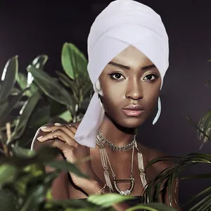 Dettaglio del turbante in velluto bianco con eleganti strati incrociati e drappo laterale