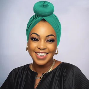 Dettaglio del turbante verde smeraldo con un elegante design a nodo a ciambella